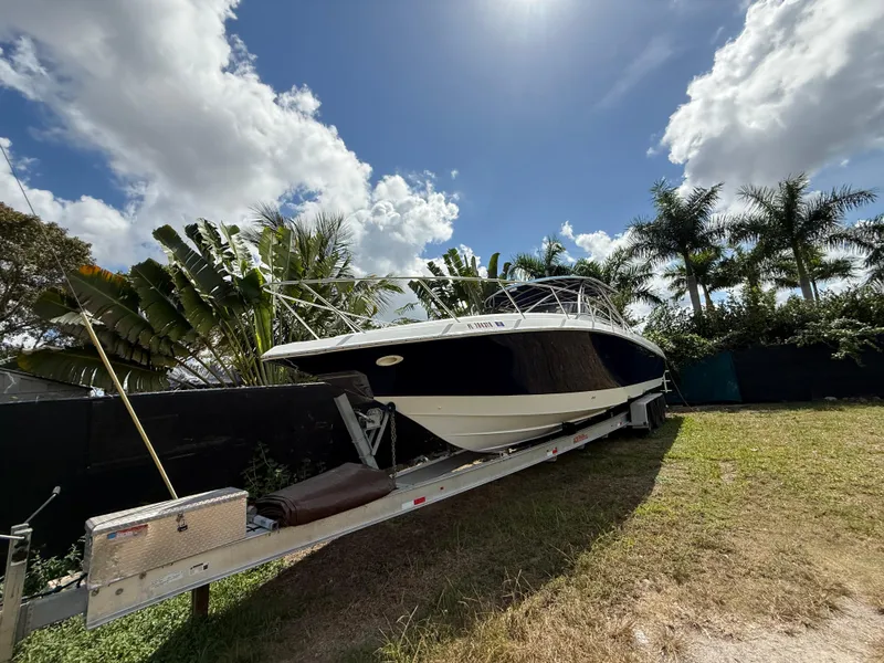 Slide: The Image of 2010 Fountain 38 LX boat on trailer, surrounded by tropical foliage under a partly cloudy sky. - 42
