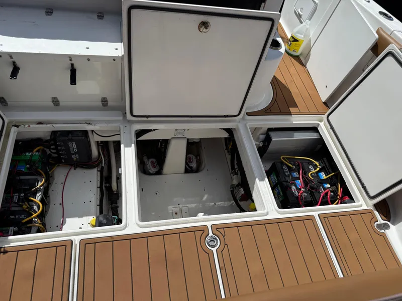 Slide: The Image of Open compartments on a 2010 Fountain 38 LX boat deck, revealing electrical and mechanical components. - 6