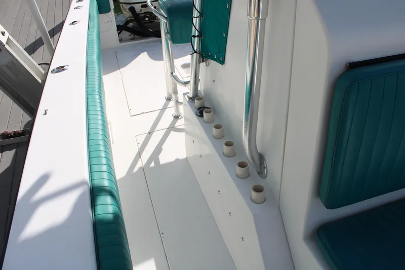 Slide: The Image of 1999 Whitewater 28 Center Console boat interior with teal seating and rod holders. - 17