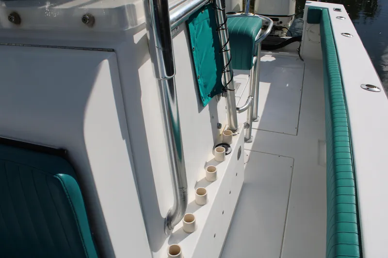 Slide: The Image of 1999 Whitewater 28 Center Console boat interior with teal accents and rod holders. - 18