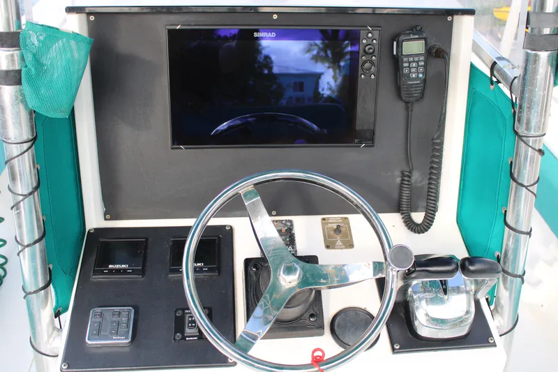 Slide: The Image of 1999 Whitewater 28 Center Console boat dashboard with steering wheel and navigation equipment. - 19