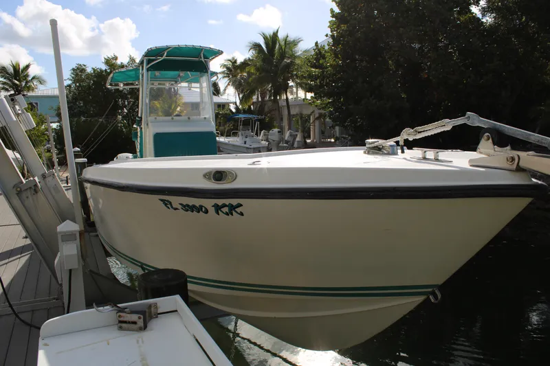 Slide: The Image of 1999 Whitewater 28 Center Console boat docked near lush greenery. - 3