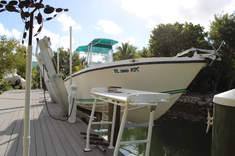 Slide: The Image of 1999 Whitewater 28 Center Console boat docked near lush greenery. - 4