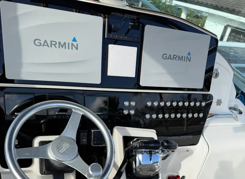 Slide: The Image of 2005 Hydra-Sports Vector 3300 VX dashboard with Garmin navigation displays and steering wheel. - 10