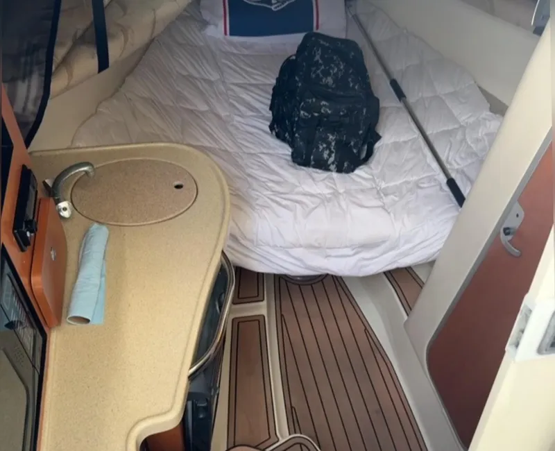 Slide: The Image of 2005 Hydra-Sports Vector 3300 VX cabin interior with bed, counter, and wooden flooring. - 16