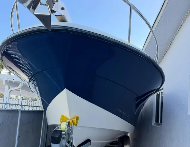 Slide: The Image of 2005 Hydra-Sports Vector 3300 VX boat with sleek blue hull, docked outdoors. - 22
