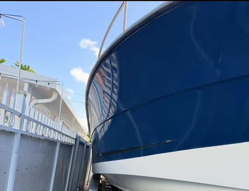 Slide: The Image of 2005 Hydra-Sports Vector 3300 VX boat with sleek blue hull, docked beside a fence. - 24