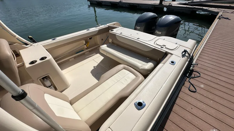 Slide: The Image of 2013 Grady-White Freedom 285 boat interior with seating and twin engines at dock. - 8