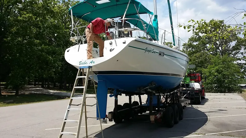 Slide: The Image of 1996 Catalina 36 MK 2 sailboat on trailer, parked in lot, person working on deck. - 2