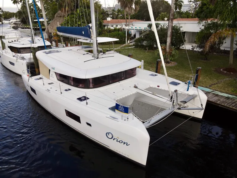 Slide: The Image of 2019 Lagoon 42 catamaran docked, featuring sleek design and spacious deck. - 0