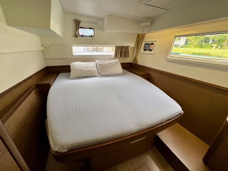 Slide: The Image of Interior cabin of a 2019 Lagoon 42 catamaran with a cozy bed and windows. - 35