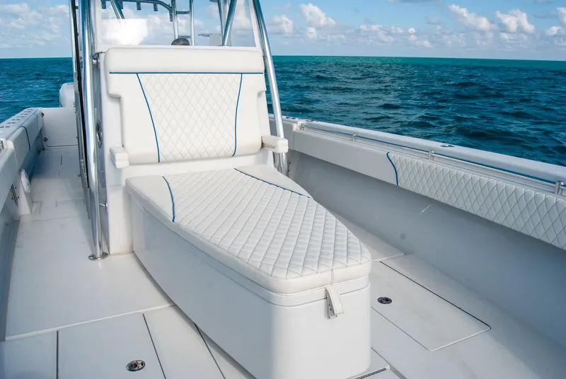 Slide: The Image of 2019 Contender 39 ST boat interior with cushioned seating, ocean view, and clear sky. - 18