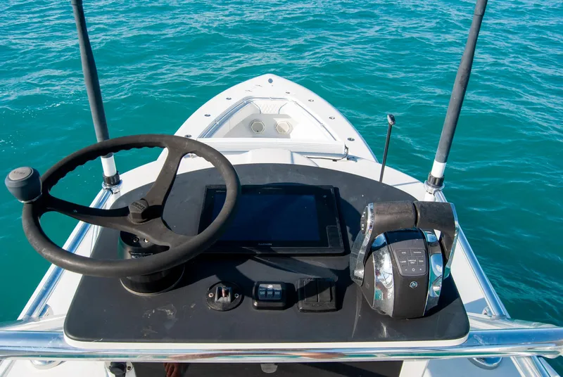 Slide: The Image of 2019 Contender 39 ST boat helm with steering wheel and controls on blue water. - 22