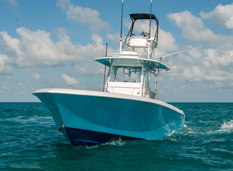 Slide: The Image of 2019 Contender 39 ST boat cruising on open water under a clear sky. - 32