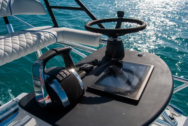 Slide: The Image of 2019 Contender 39 ST boat helm with steering wheel and throttle on open water. - 6