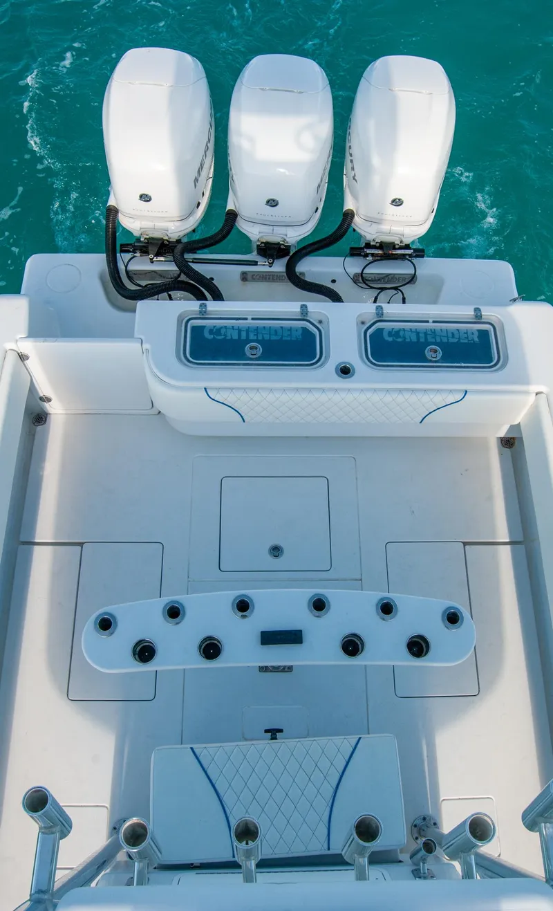 Slide: The Image of 2019 Contender 39 ST boat with triple outboard engines on turquoise water. - 9