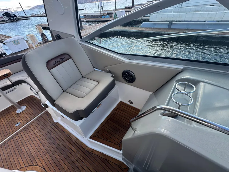 Slide: The Image of 2016 Sea Ray 370 Sundancer cockpit with luxurious seating and wood flooring. - 14