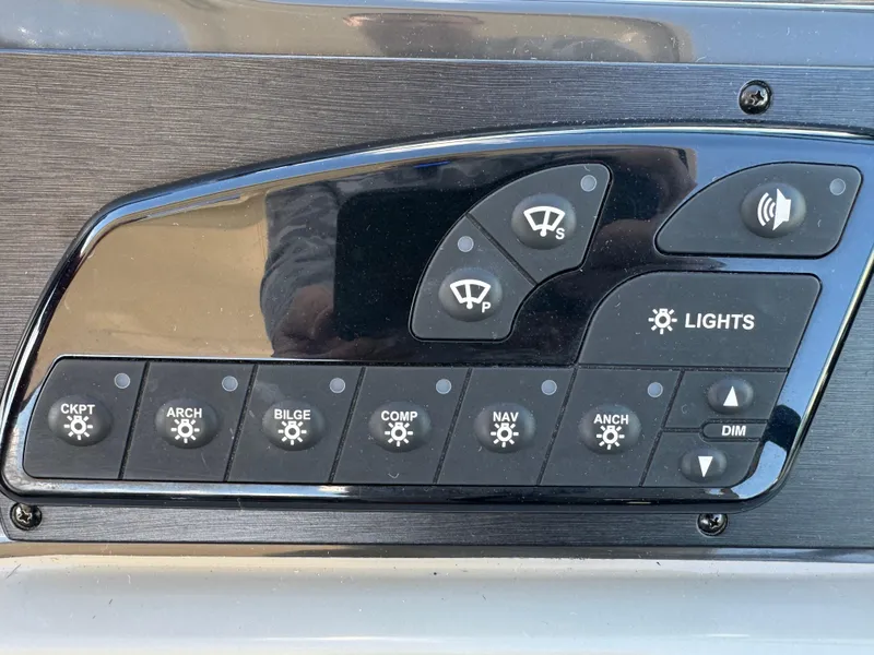 Slide: The Image of Control panel of a 2016 Sea Ray 370 Sundancer boat with various switches. - 15