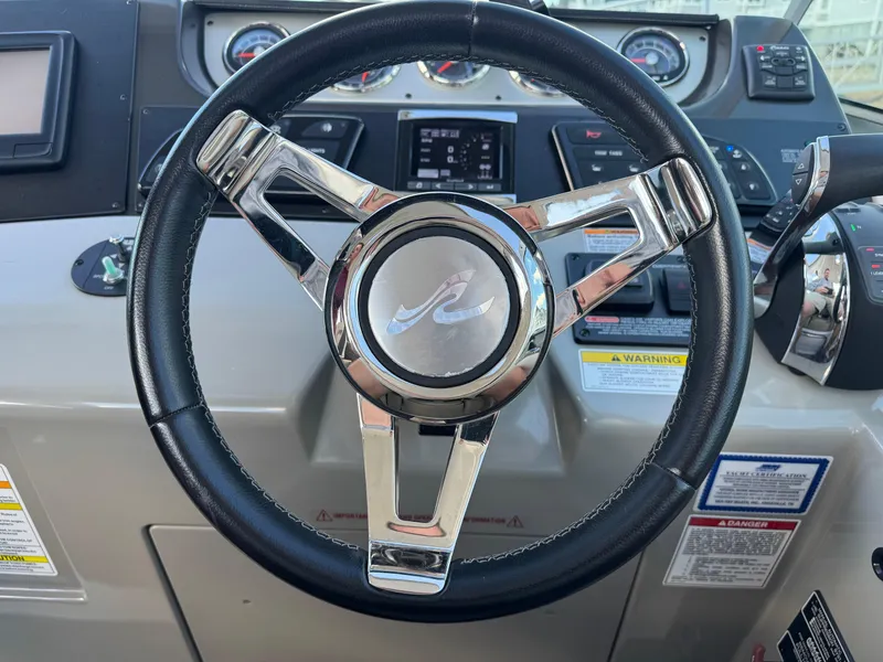 Slide: The Image of Steering wheel of a 2016 Sea Ray 370 Sundancer boat, featuring chrome accents. - 17