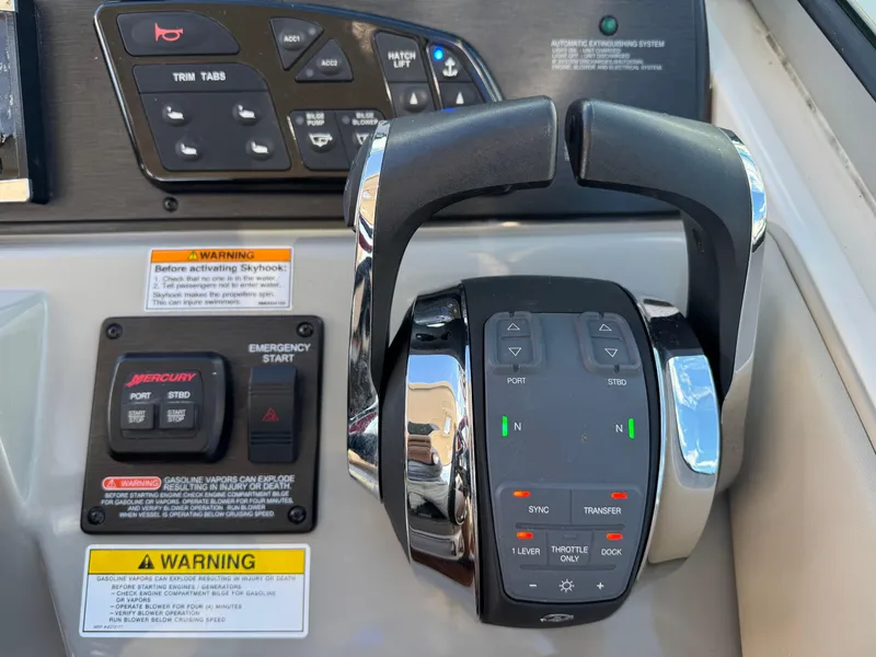 Slide: The Image of Control panel of a 2016 Sea Ray 370 Sundancer boat with throttle and warning labels. - 20