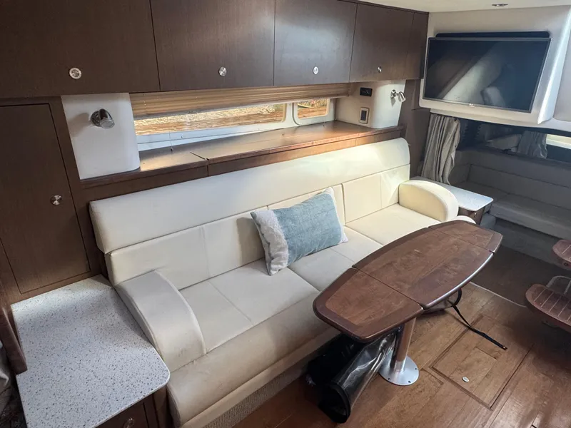 Slide: The Image of Interior of 2016 Sea Ray 370 Sundancer with white sofa and wooden table. - 26