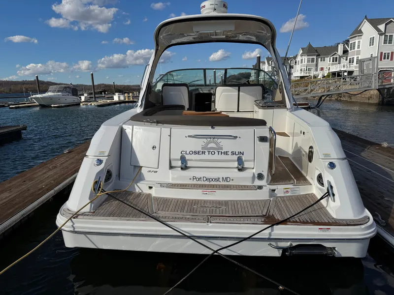 Slide: The Image of 2016 Sea Ray 370 Sundancer docked at marina, rear view with open cockpit. - 3