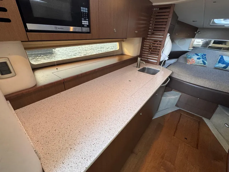 Slide: The Image of Interior of 2016 Sea Ray 370 Sundancer with kitchenette and sleeping area. - 32
