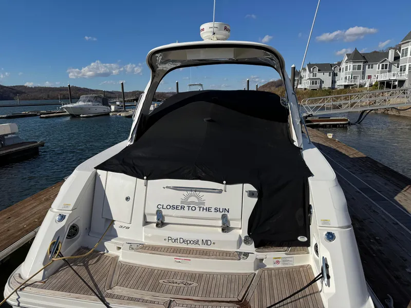 Slide: The Image of Sea Ray 370 Sundancer 2016 docked at marina, covered, with scenic waterfront view. - 6