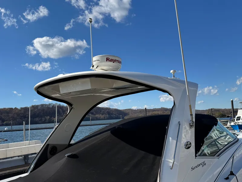 Slide: The Image of 2016 Sea Ray 370 Sundancer boat docked under a clear blue sky. - 7