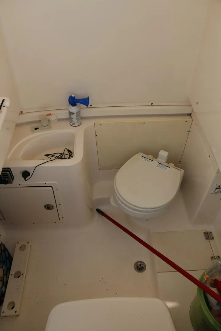 Slide: The Image of 2013 Robalo R300 Center Console boat bathroom interior with toilet and sink. - 10