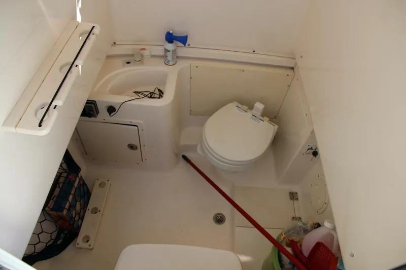 Slide: The Image of 2013 Robalo R300 Center Console boat bathroom with toilet and sink. - 11