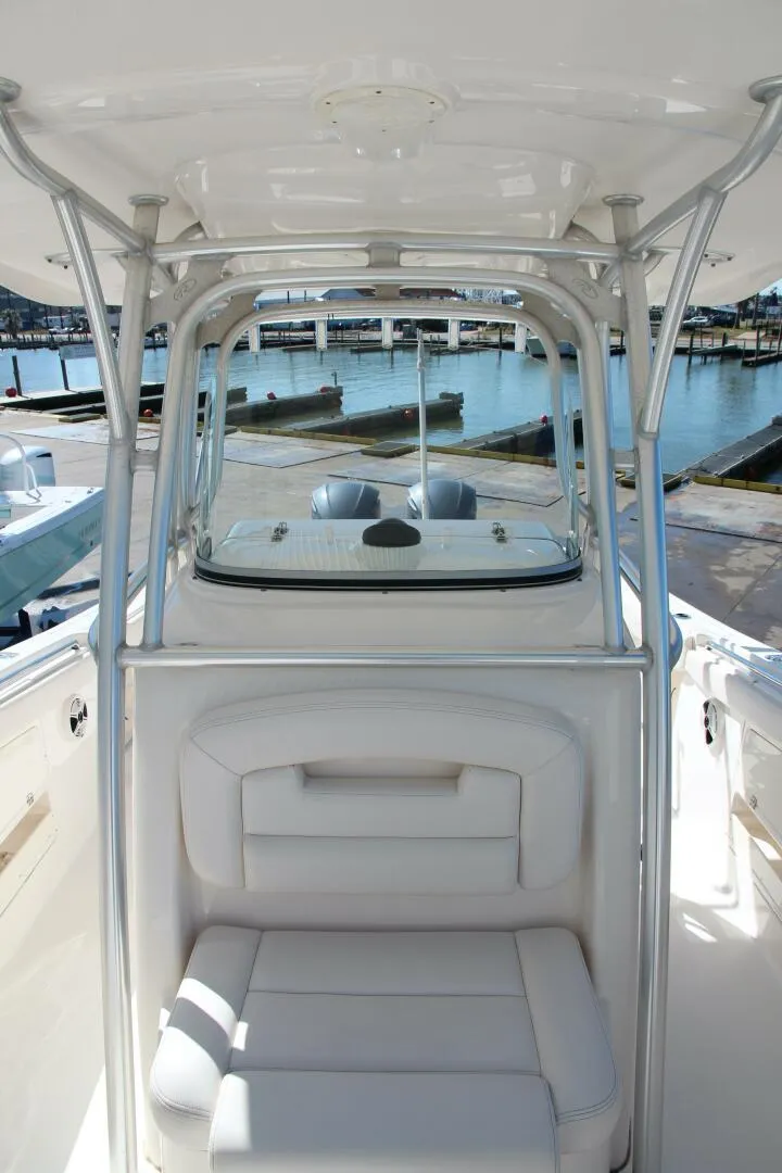 Slide: The Image of 2013 Robalo R300 Center Console boat interior with seating and marina view. - 14