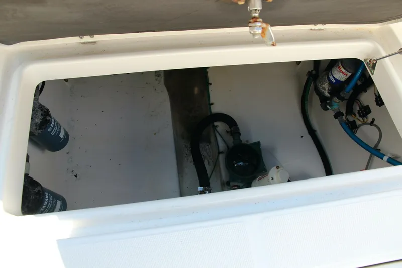 Slide: The Image of 2013 Robalo R300 Center Console storage compartment with visible hoses and equipment. - 22