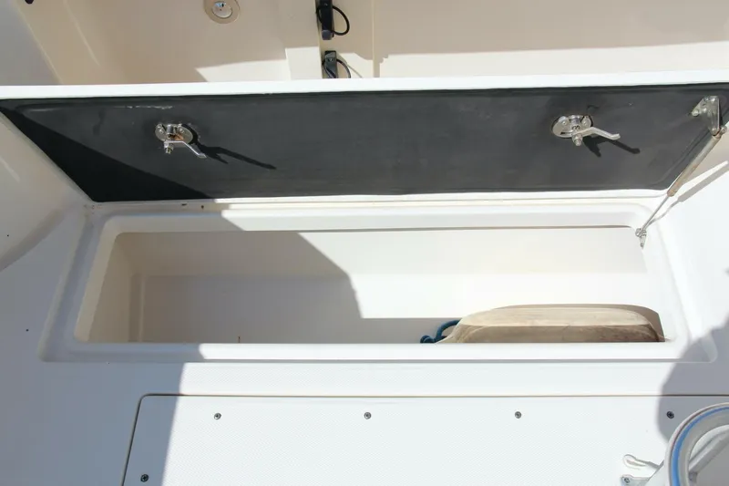 Slide: The Image of 2013 Robalo R300 Center Console storage compartment with open lid. - 24