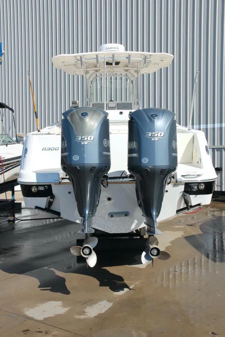 Slide: The Image of 2013 Robalo R300 Center Console boat with twin Yamaha 350 engines, docked outdoors. - 26