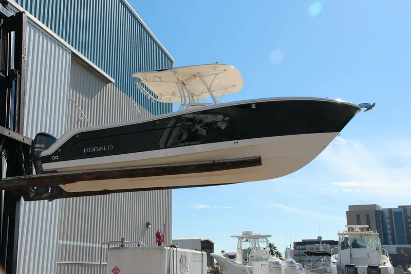 Slide: The Image of 2013 Robalo R300 Center Console boat lifted at marina. - 28