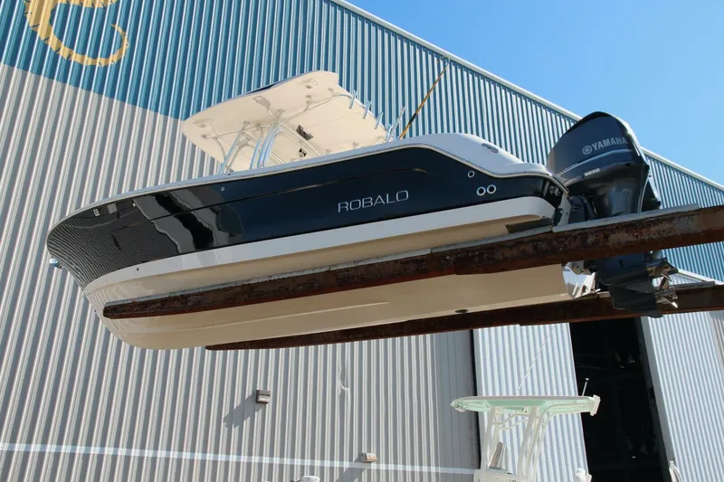Slide: The Image of 2013 Robalo R300 Center Console boat with Yamaha engine, docked near a warehouse. - 29
