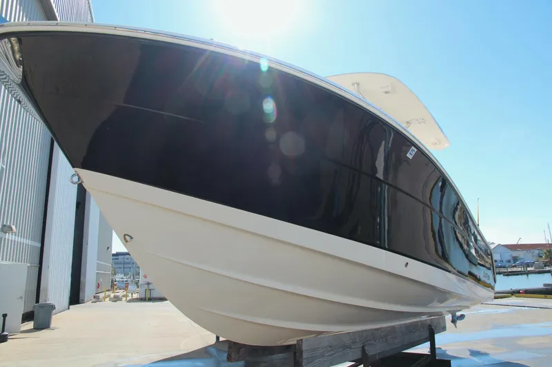 Slide: The Image of 2013 Robalo R300 Center Console boat on display in a marina setting. - 32