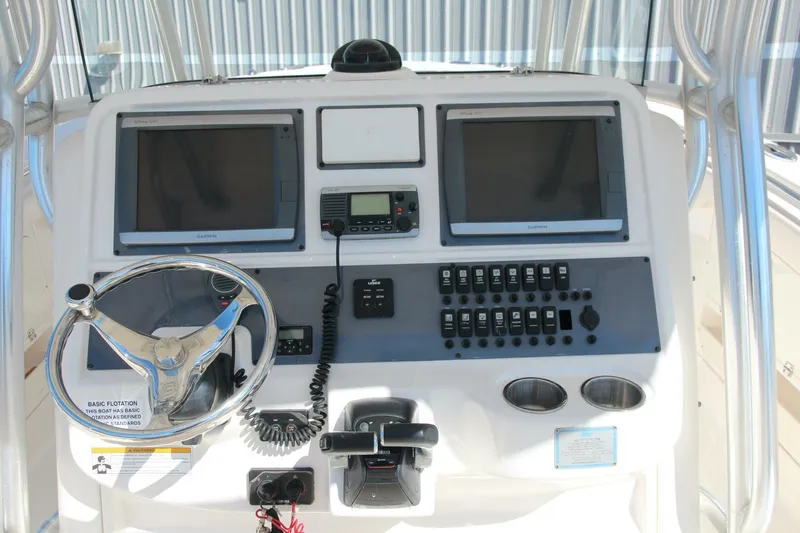 Slide: The Image of 2013 Robalo R300 Center Console boat dashboard with dual screens and controls. - 5
