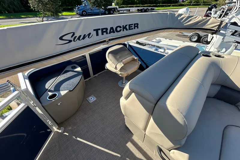Slide: The Image of 2025 Sun Tracker Fishin' Barge 20 DLX interior with seating and storage compartments. - 4