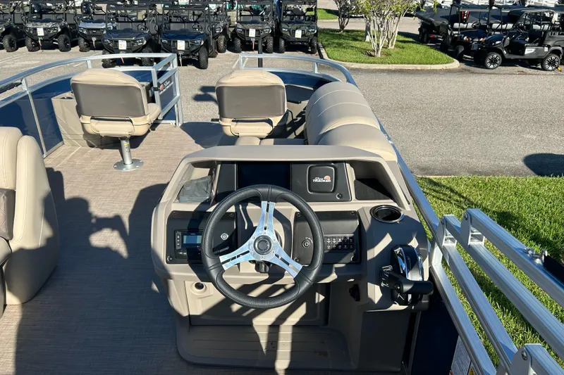 Slide: The Image of 2025 Sun Tracker Fishin' Barge 20 DLX interior with steering wheel and seating. - 5