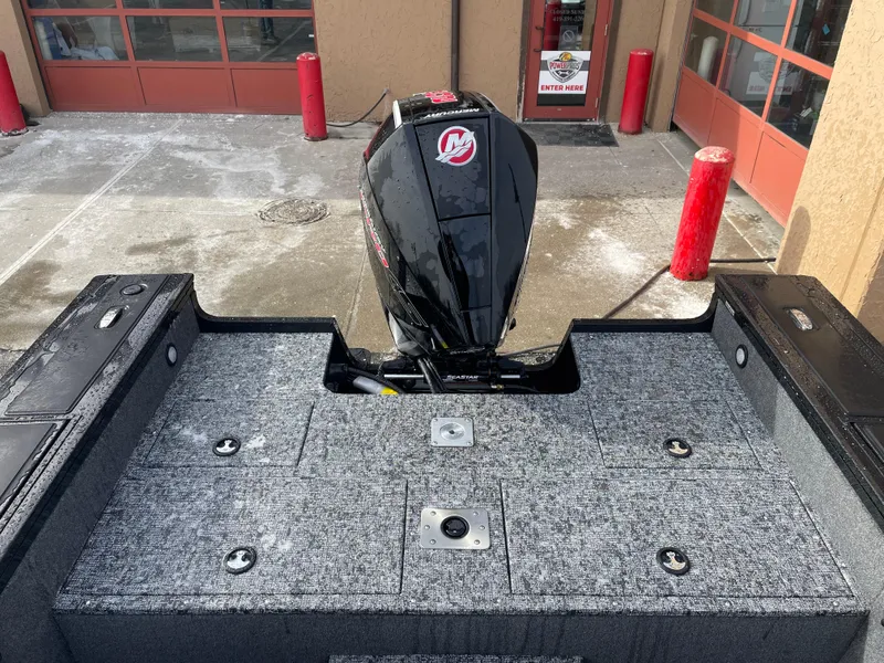 Slide: The Image of 2025 Tracker Targa V-19 WT boat with Mercury outboard motor, parked outside a building. - 5