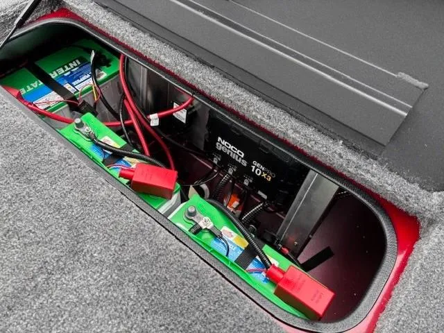 Slide: The Image of Battery compartment of 2025 Tracker Savage 215 with wiring and NOCO Genius charger. - 27