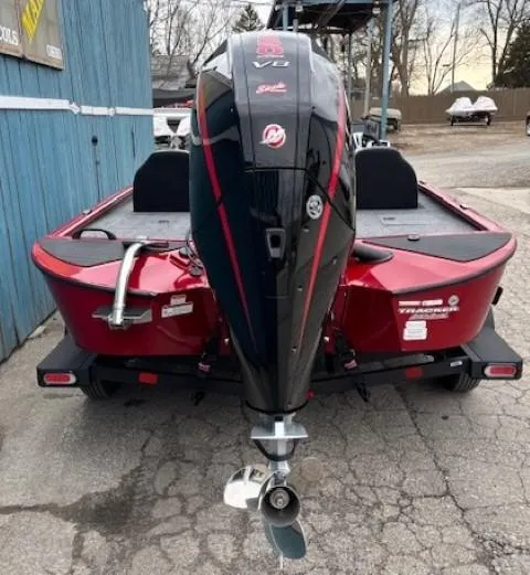 Slide: The Image of 2025 Tracker Savage 215 boat, rear view, red and black design, parked on concrete. - 3
