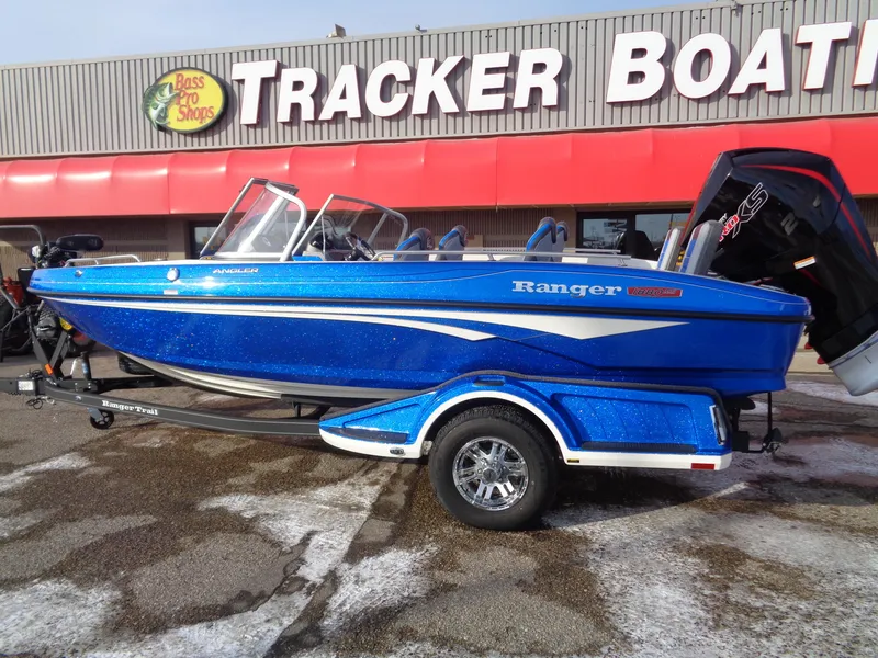 Slide: The Image of 2024 Ranger 1880MS boat in blue, displayed at Tracker Boats dealership. - 2