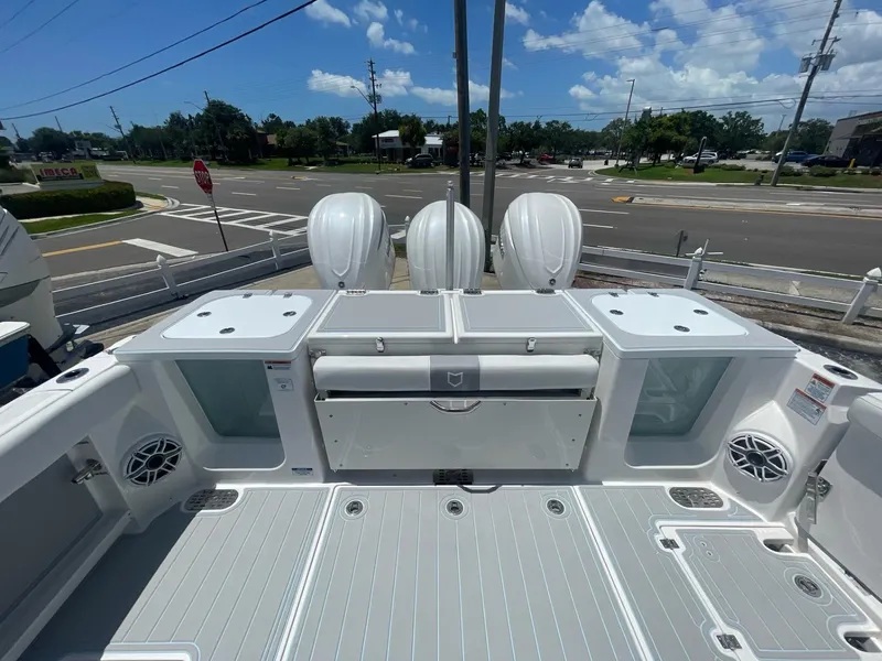 Slide: The Image of 2020 Sea Fox 368 Commander boat deck with triple outboard engines, parked near a road. - 31