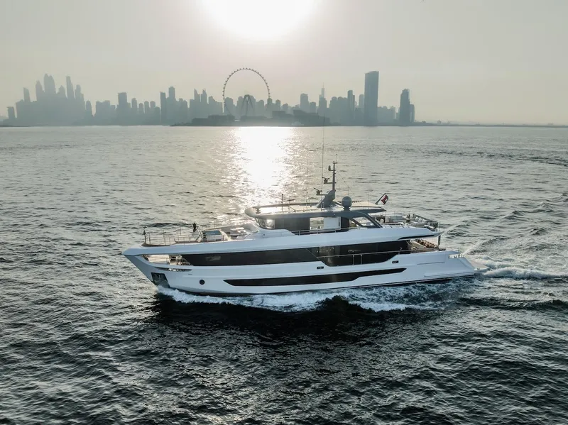 Slide: The Image of Majesty 100 Terrace yacht cruising with city skyline and Ferris wheel in background, 2025 model. - 12