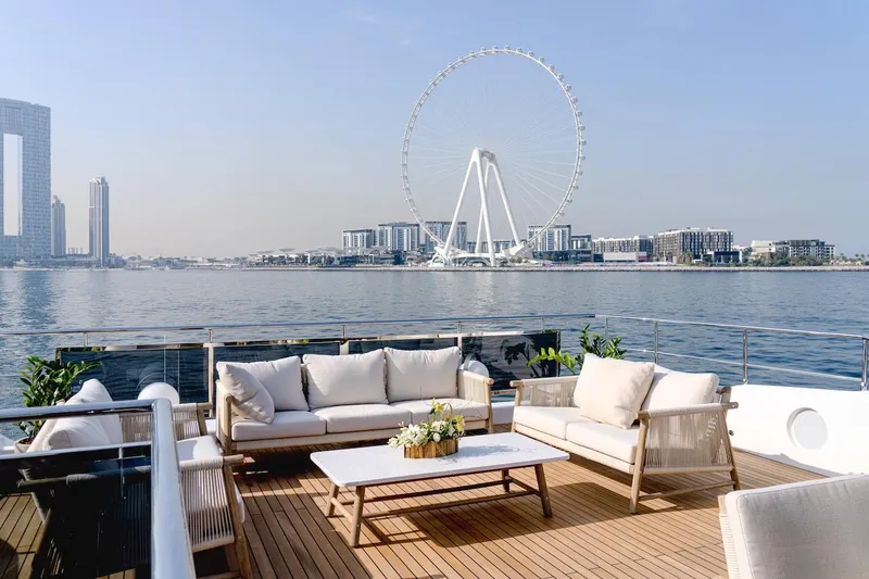 Slide: The Image of Luxurious Majesty 100 Terrace yacht deck with cityscape and Ferris wheel view, 2025 model. - 23