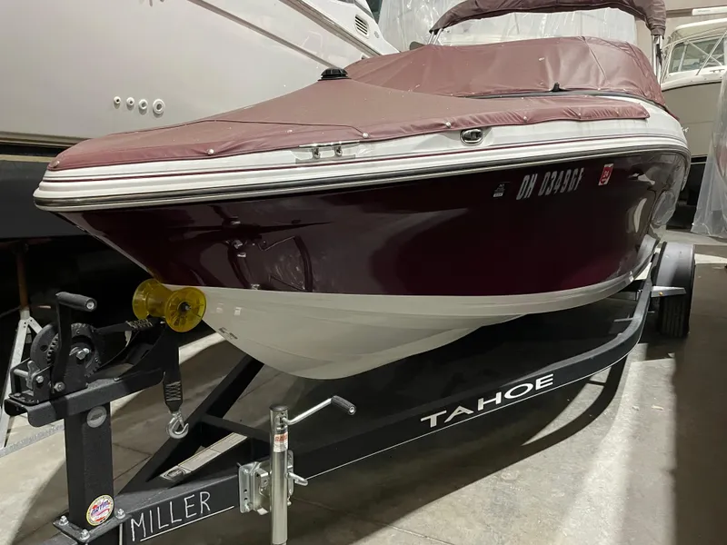Slide: The Image of 2021 Tahoe 550 TS boat on trailer in storage, maroon cover, side view. - 1