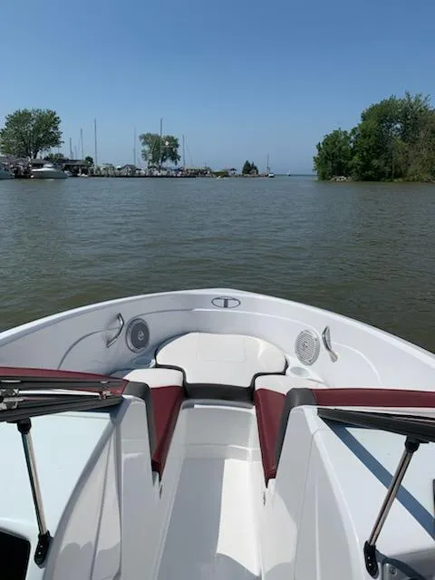 Slide: The Image of 2021 Tahoe 550 TS boat on calm lake with clear sky and distant shoreline. - 5
